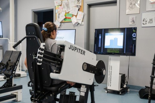 Pacjentka ćwiczy na urządzeniu Jupiter, obserwując wyniki treningu na monitorze. 